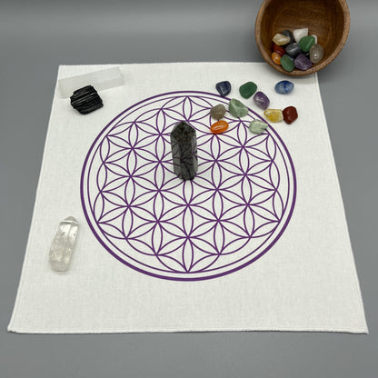 12 Inch Flower of Life Crystal Grid Cloth with Tumbled Crystals and a Crystal Tower Placed on it and complete with Clear Quartz Point, Selenite Wand, and Black Tourmaline Displaying the Grid Cloth in Use.