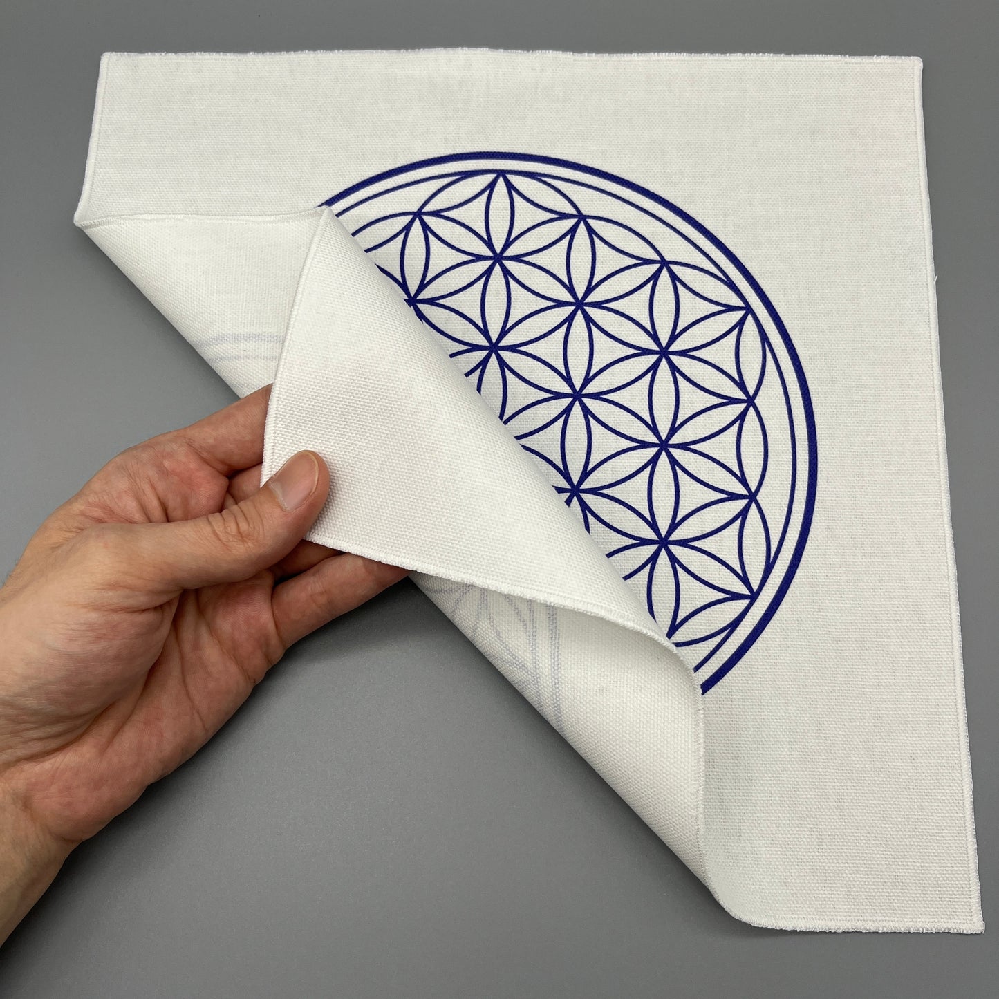 12 Inch Flower of Life Crystal Grid Cloth Being Held Up to Show the Black Back Side and Flower of Life Symbol Showing Through Slightly