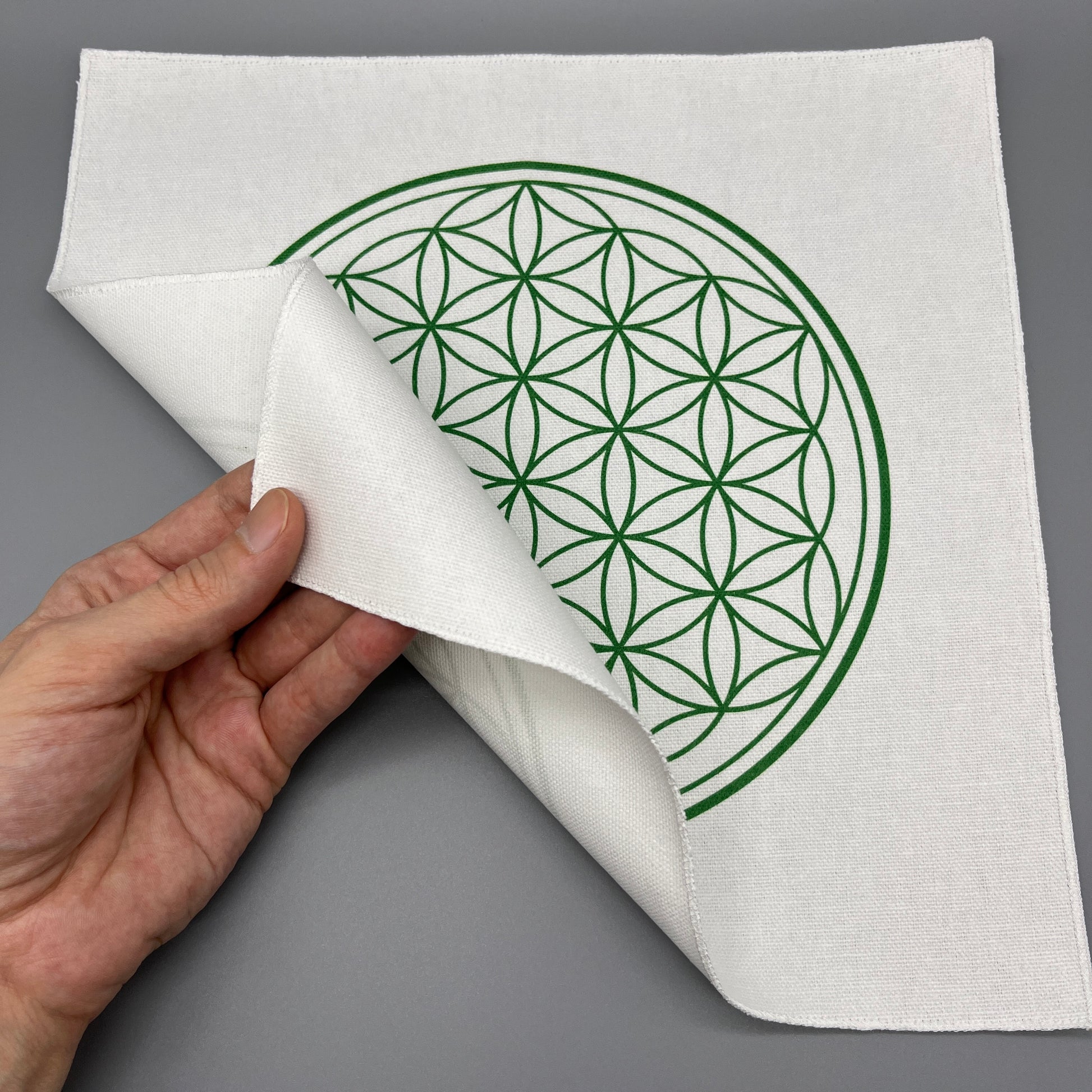 12 Inch Flower of Life Crystal Grid Cloth Being Held Up to Show the Black Back Side and Flower of Life Symbol Showing Through Slightly