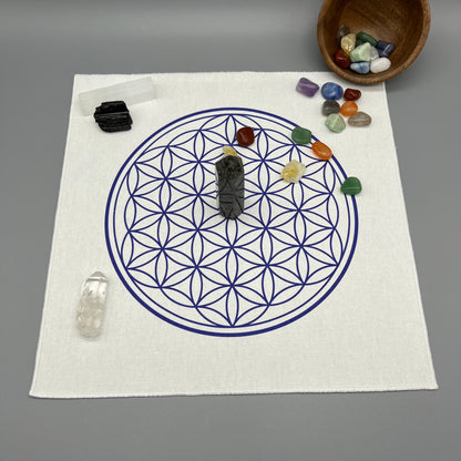 12 Inch Flower of Life Crystal Grid Cloth with Tumbled Crystals and a Crystal Tower Placed on it and complete with Clear Quartz Point, Selenite Wand, and Black Tourmaline Displaying the Grid Cloth in Use.